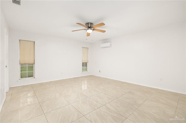 unfurnished room with light tile patterned floors, visible vents, baseboards, ceiling fan, and a wall mounted AC