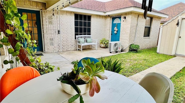 6916 Avenida Del Paseo St, Mission, TX 78572 - view of exterior entry featuring brick siding, ac unit, roof with shingles, and a patio