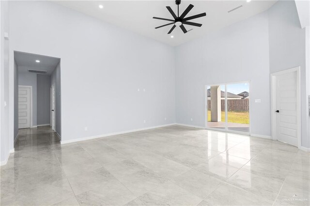 empty room with ceiling fan and a high ceiling