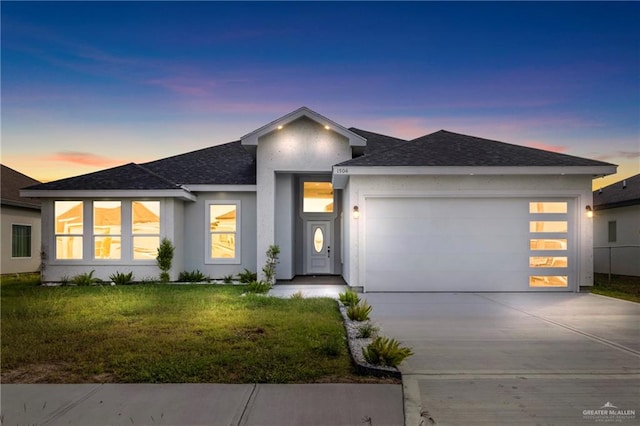 view of front of house with a garage and a yard