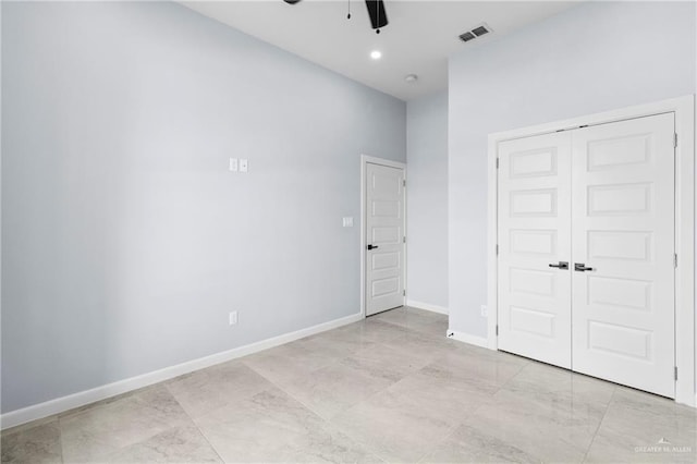 unfurnished bedroom featuring ceiling fan and a closet