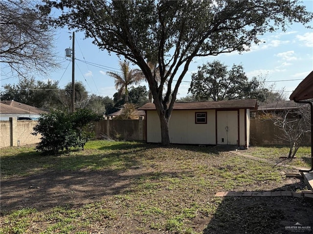 view of yard featuring a shed, fence, and an outdoor structure