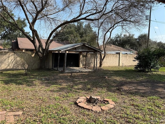 view of yard with an outdoor fire pit, a fenced backyard, and a patio