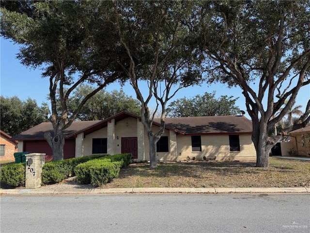 single story home featuring brick siding and an attached garage