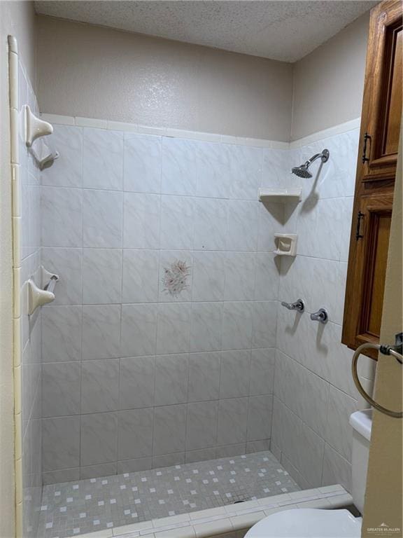 full bathroom featuring a stall shower, a textured ceiling, and toilet