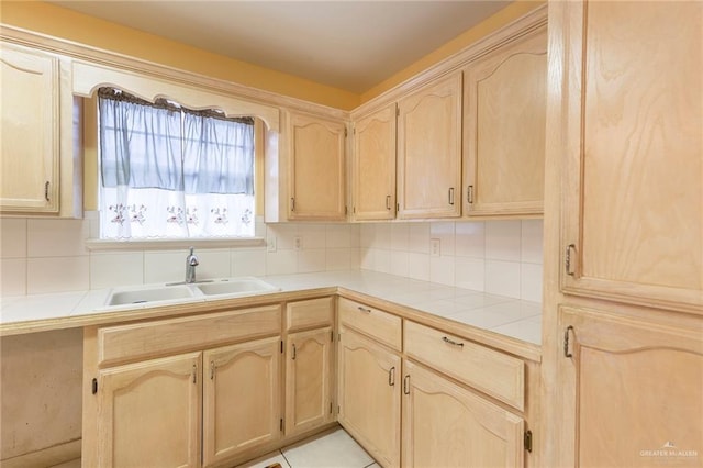 kitchen with sink, tile countertops, and light brown cabinets