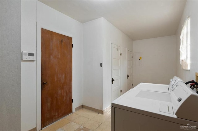 laundry room with light floors, washing machine and dryer, baseboards, and laundry area