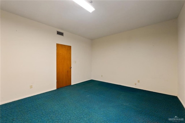 empty room with carpet floors, visible vents, and baseboards