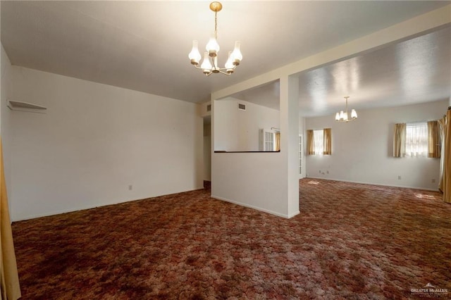 carpeted empty room with visible vents and an inviting chandelier