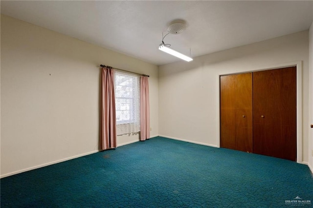 carpeted spare room with baseboards