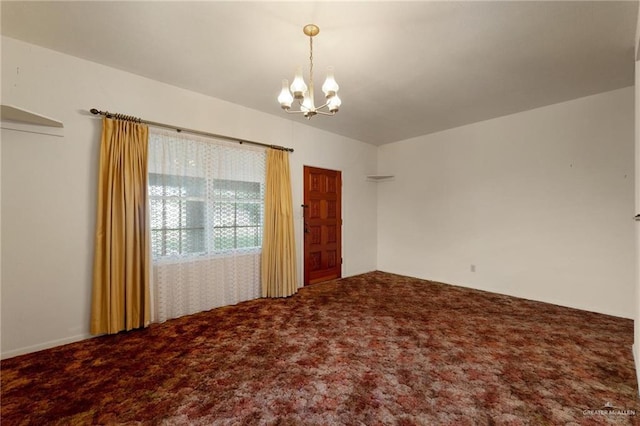 spare room with carpet floors and a notable chandelier