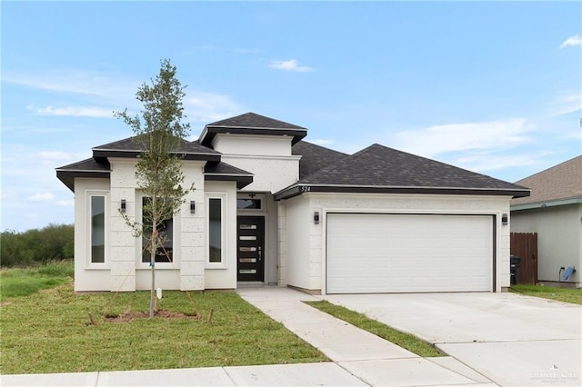 prairie-style house featuring a garage and a front yard