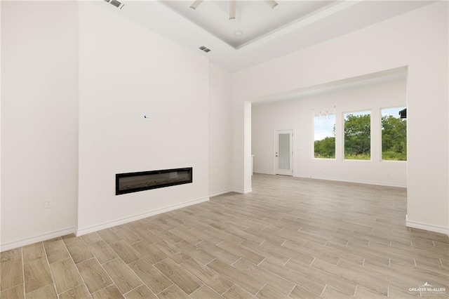 unfurnished living room with a raised ceiling