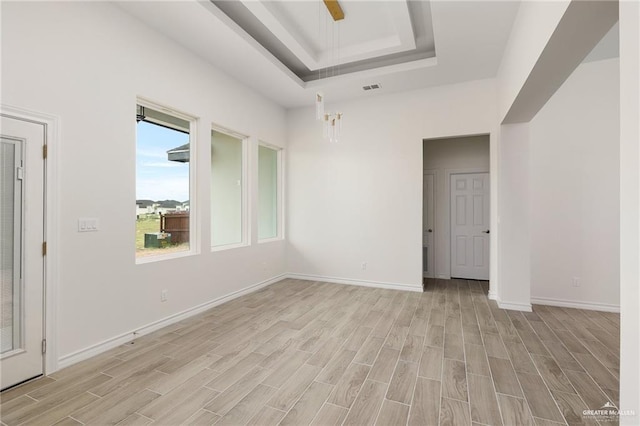 spare room featuring a tray ceiling and ceiling fan