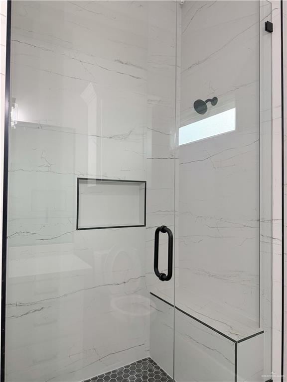 bathroom with a shower with door