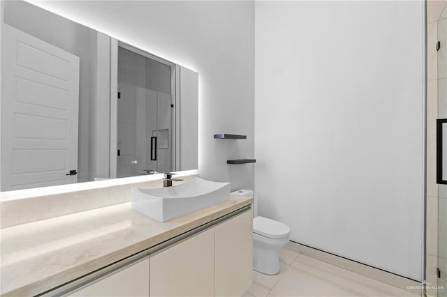 bathroom with vanity, toilet, tile patterned flooring, and a shower with door