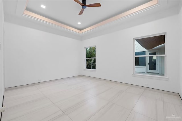 spare room with a raised ceiling and ceiling fan