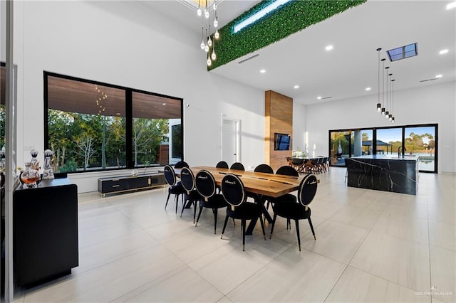 dining area featuring light tile patterned floors and a high ceiling