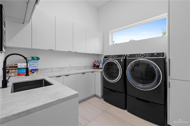 clothes washing area featuring cabinets, separate washer and dryer, and sink