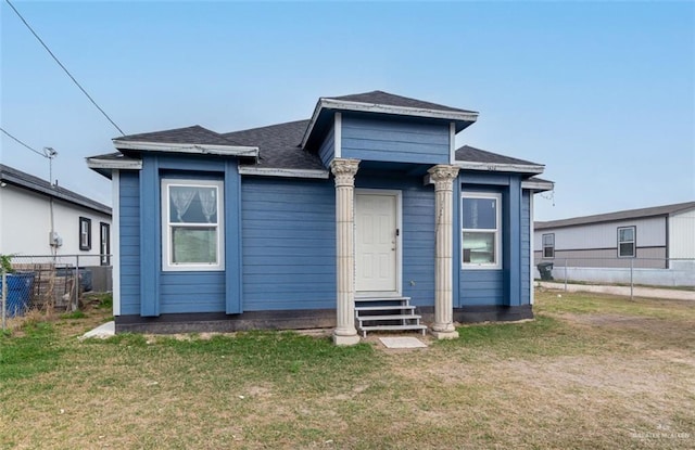 view of front of home featuring a front yard, fence, and entry steps