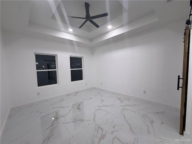unfurnished room with a raised ceiling, baseboards, recessed lighting, ceiling fan, and marble finish floors