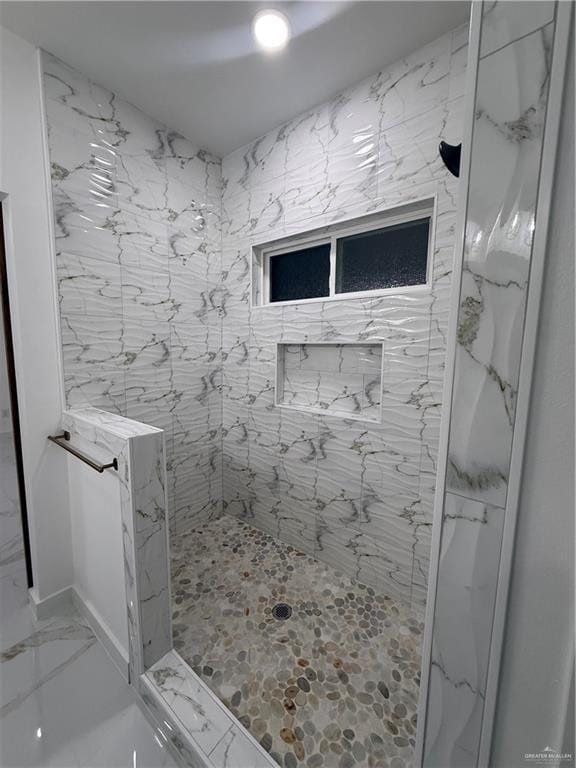 full bath featuring a marble finish shower and marble finish floors