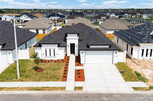1008 N Buxton Ave, Edinburg, TX 78541 - view of front of home featuring a residential view, an attached garage, driveway, stucco siding, and a shingled roof