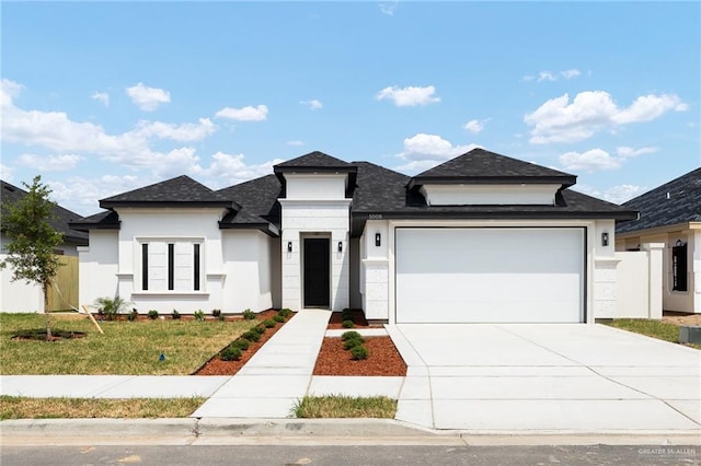 1008 N Buxton Ave, Edinburg, TX 78541 - view of front of home with a garage, driveway, roof with shingles, stucco siding, and a front yard