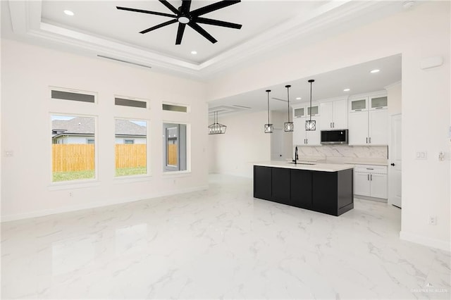 1008 N Buxton Ave, Edinburg, TX 78541 - kitchen featuring stainless steel microwave, a sink, baseboards, a ceiling fan, and white cabinets