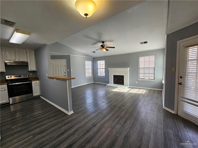 kitchen with a fireplace, lofted ceiling, ceiling fan, dark hardwood / wood-style flooring, and electric range