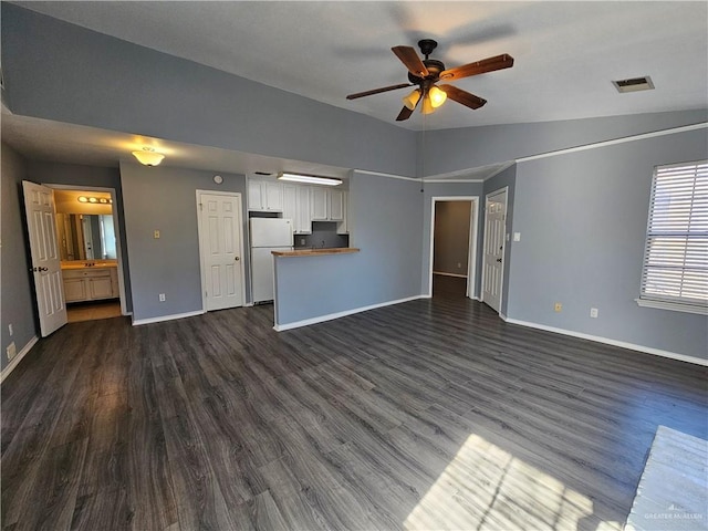 unfurnished living room with lofted ceiling, ceiling fan, and dark wood-type flooring