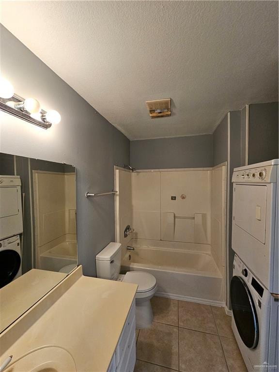 full bathroom with tile patterned flooring, stacked washing maching and dryer, shower / bathing tub combination, and a textured ceiling