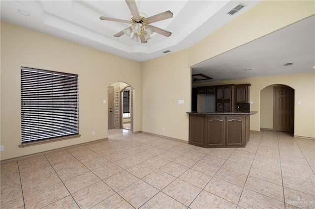 interior space with dark brown cabinetry, ceiling fan, and light tile patterned floors