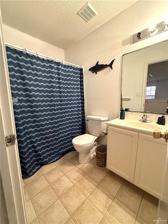 1341 Kokopelli Dr, Edinburg, TX 78541 - full bath featuring a textured ceiling, toilet, vanity, and tile patterned floors