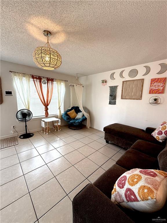 1341 Kokopelli Dr, Edinburg, TX 78541 - living room with light tile patterned floors and a textured ceiling