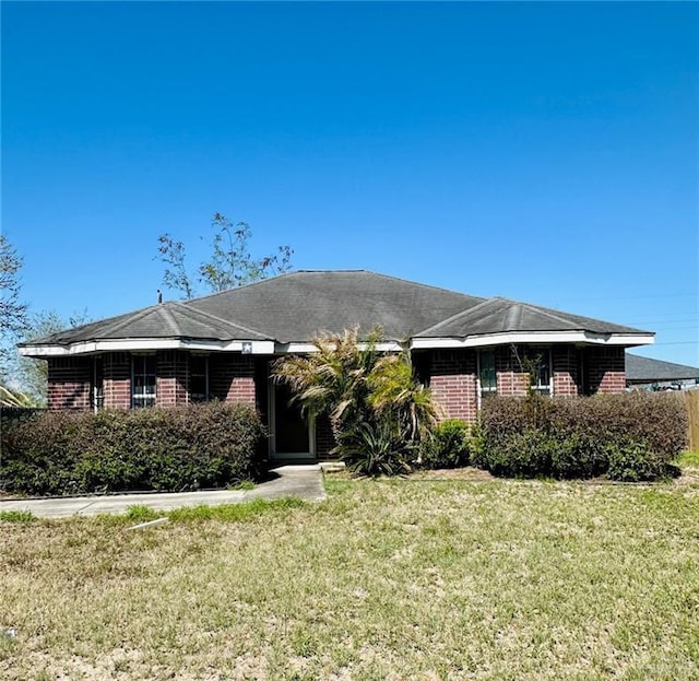 single story home featuring brick siding and a front lawn