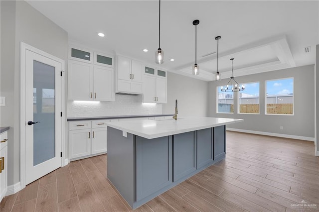 2427 Summer Breeze St, Mission, TX 78572 - kitchen featuring a raised ceiling, light wood-type flooring, white cabinets, tasteful backsplash, and recessed lighting