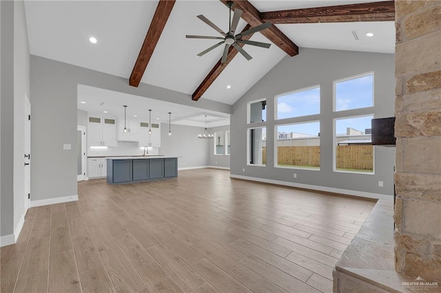 2427 Summer Breeze St, Mission, TX 78572 - unfurnished living room featuring a ceiling fan, beamed ceiling, a chandelier, high vaulted ceiling, and light wood-style flooring