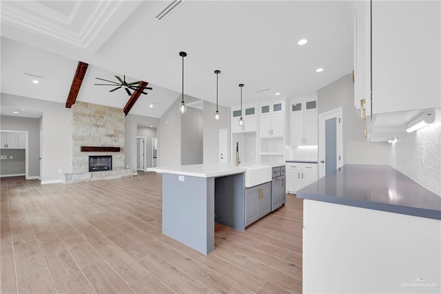 2427 Summer Breeze St, Mission, TX 78572 - kitchen featuring white cabinets, gray cabinetry, light wood-style flooring, ceiling fan, and a kitchen island
