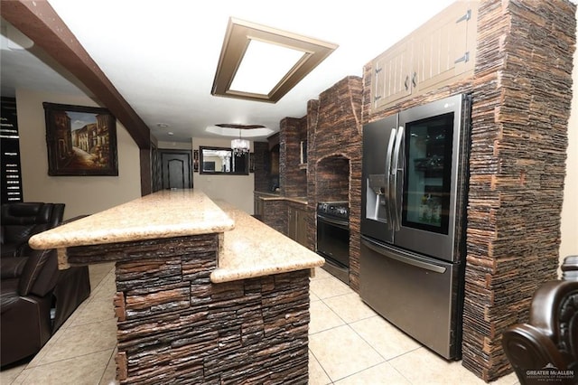 5310 Nicole Dr, Edinburg, TX 78542 - kitchen featuring stainless steel refrigerator with ice dispenser, stove, light tile patterned floors, light stone counters, and a center island