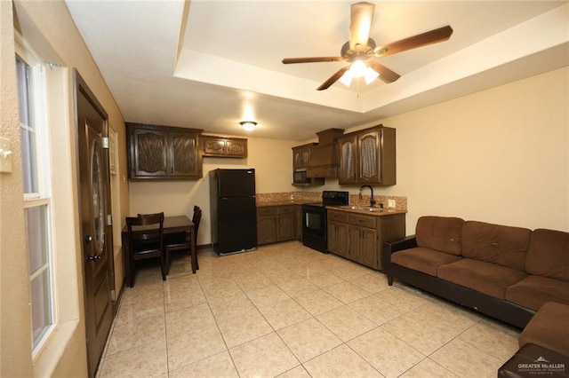 5310 Nicole Dr, Edinburg, TX 78542 - kitchen with black appliances, dark brown cabinetry, a raised ceiling, a ceiling fan, and light tile patterned floors