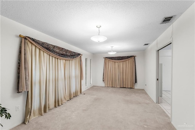 carpeted spare room with a textured ceiling