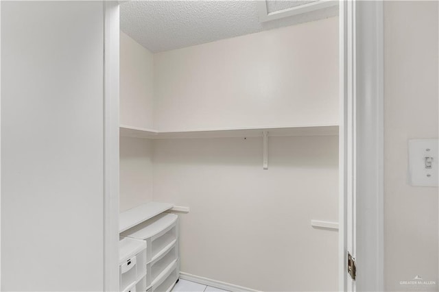 spacious closet with light tile patterned floors