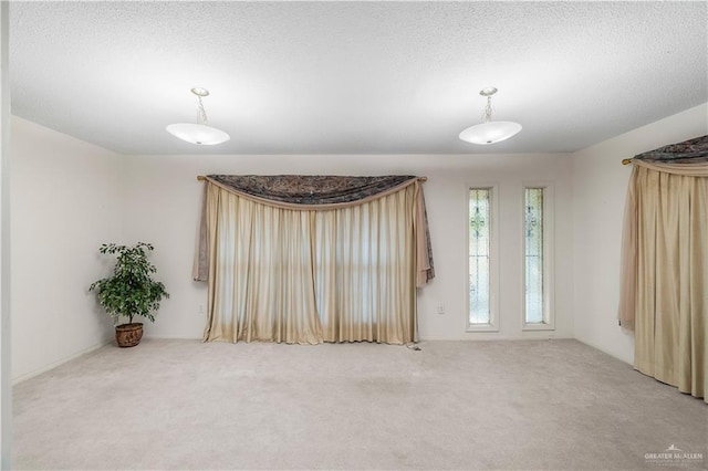 carpeted empty room with a textured ceiling