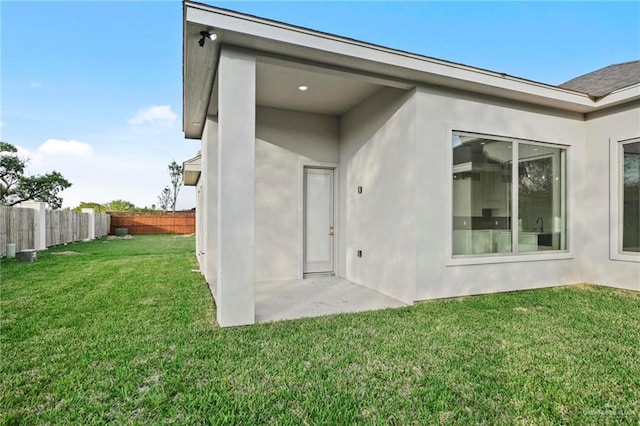 entrance to property with a yard and a patio