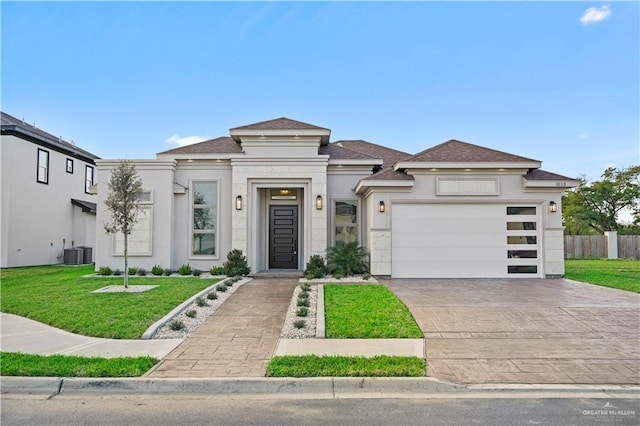 view of front of house with a front lawn, a garage, and central AC unit