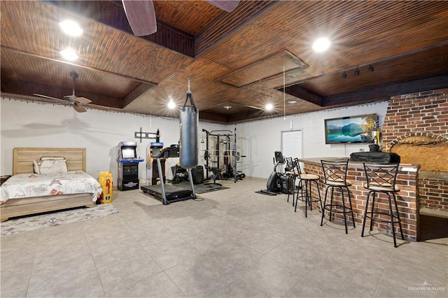 exercise area featuring a raised ceiling, ceiling fan, wooden ceiling, and indoor bar