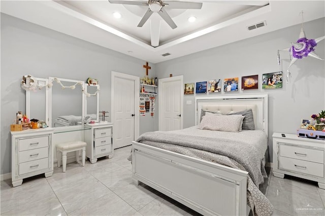 bedroom with a raised ceiling and ceiling fan