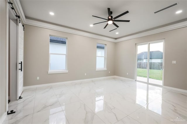 spare room with a barn door, ceiling fan, and ornamental molding