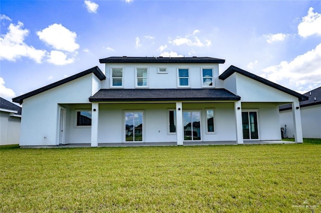 rear view of house featuring a lawn and a patio